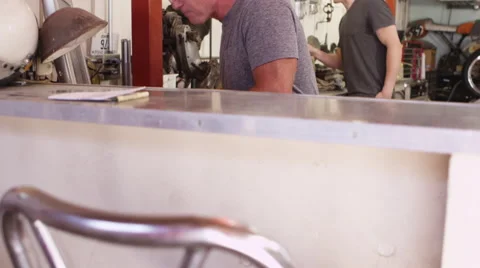 Two men working in a mechanics office Stock-Footage 67345907