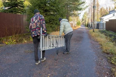 Two men working on utility pole with ladder on rural road Foto stock