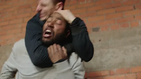 Two men wrestle and chokehold and punch in an industrial staircase, in moody lig Stock Footage 199458190