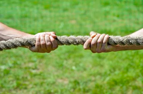 Two men's hands pull the rope each in his own direction. The concept of dispu Foto stock