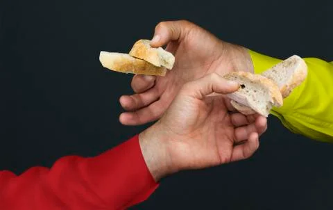 Two men's hands with two peaces of a white bread Stock Photos