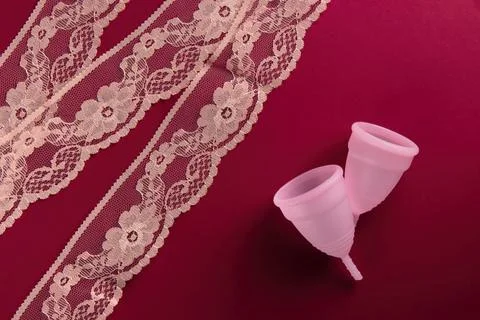 Two menstrual cups of different sizes, made of soft medical silicone, lie on  Stock Photos