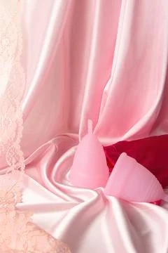 Two menstrual cups of different sizes made of medical silicone, against the b Stock Photos