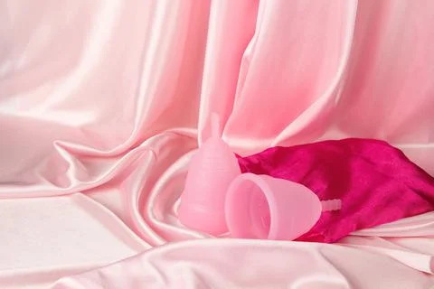 Two menstrual cups of different sizes made of medical silicone, against the b Stock Photos