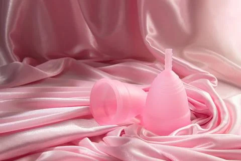 Two menstrual cups of different sizes made of medical silicone, against the b Stock Photos