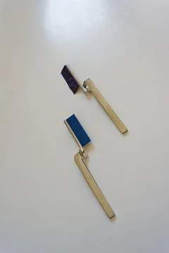 Two metal paint rollers with blue and purple paint on a white surface Stock Photos