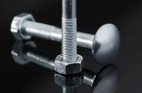 Two metal screws with nice reflection on black background. Stock Photos