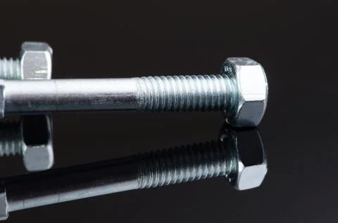 Two metal screws with nice reflection on black background. Stock Photos
