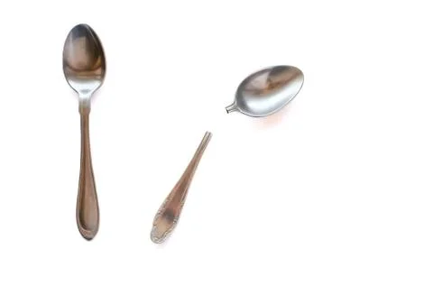 Two metal teaspoons - broken in half and serviceable on a white background. The Stock Photos