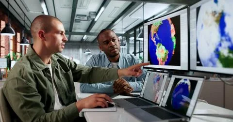 Two Meteorologists Analyze Climate Data On Computers To Forecast Hurricanes. Stock Photos