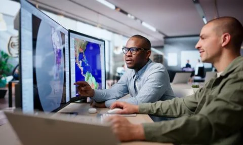 Two Meteorologists Analyze Climate Data On Computers Predicting Hurricane Imp Stock Photos