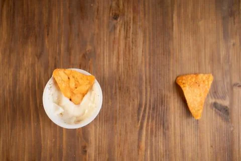 Two Mexican corn chips nachos lie on a wooden table. One thing in a bowl with Stock Photos