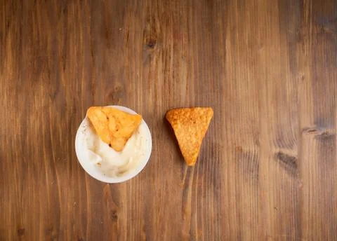 Two Mexican corn chips nachos lie on a wooden table. One thing in a bowl with Stock Photos