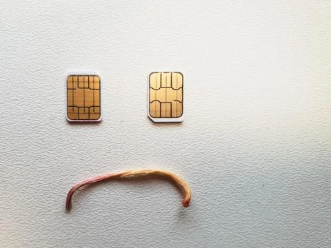 Two micro sim cards lying in the shape of a sad face Stock Photos