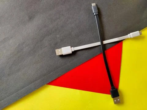 Two micro USB cables in white and black color kept like plus sign. Isolated o Stock Photos