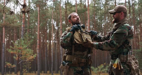 Two middle-aged bearded soldiers in woodland military uniform put on full Stock Footage 144166757