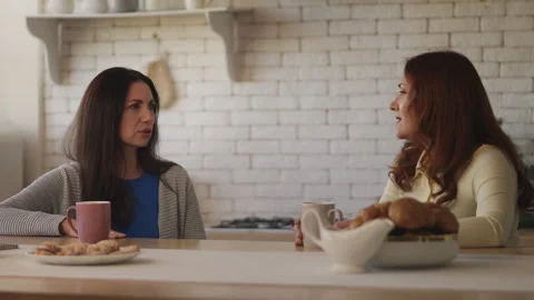Two middle-aged housewives gossiping over tea at home, friendship concept Stock Footage 337946845