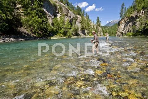 Two middle-aged men fly-fishing on Bull river, East Kootenays, BC, Canada. Stock Photos