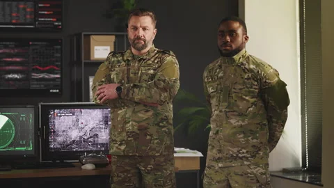 Two military officers standing in command center with satellite data screens Stock Footage 335539348