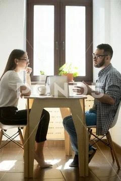Two millennial colleagues discussing new business concept at wor Stock Photos