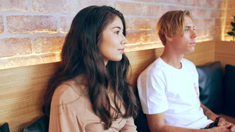 Two millennial friends wait in coffee shop in Australia. The man looks out in fr Stock Footage 199461175