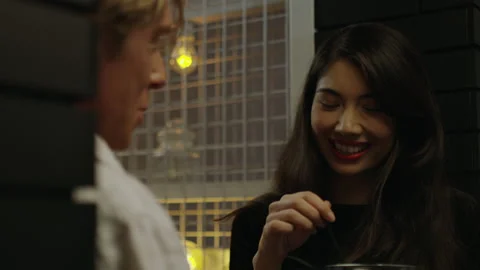 Two millennials flirt at a club while sipping drinks in Australia. Medium to clo Stock Footage 199456243