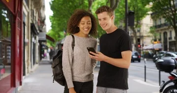Two millennials lost on Paris streets use map on smartphone Stock Footage 85595127