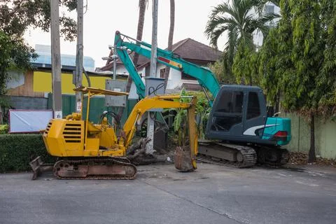 Two Mini Excavators Prepare the soil from a canal in the city. Stock Photos