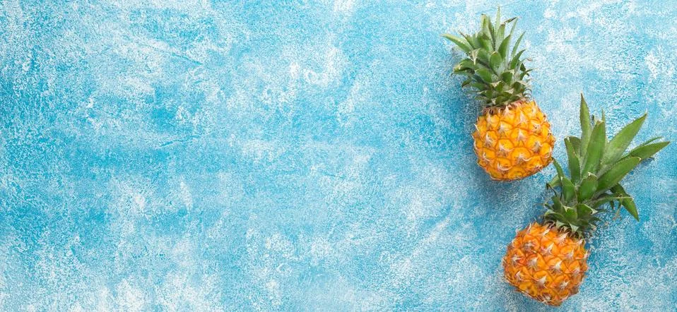 Two mini pineapples on a blue background Stock Photos