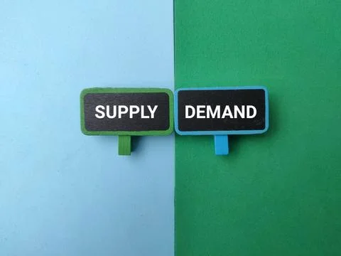 Two mini signboards marked SUPPLY and DEMAND sit side-by-side against a spl.. Stock Photos