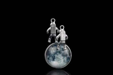 Two miniature astronauts floating in space against the Moon's face. Stockfoto's