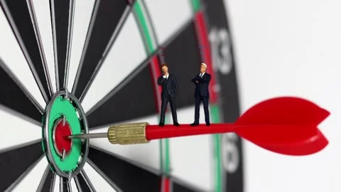 Two miniature people standing on target and arrowhead. Stock Footage 287898323