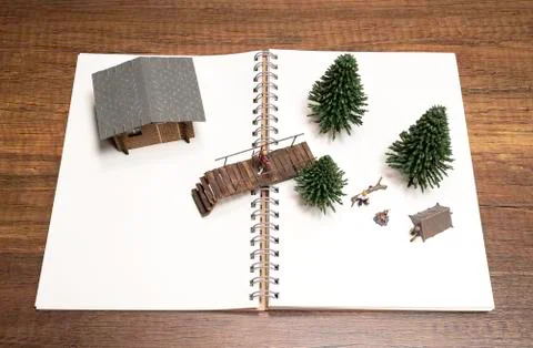 Two miniatures camping with Pine tree, Bridge and House on white blank notebook Stock Photos