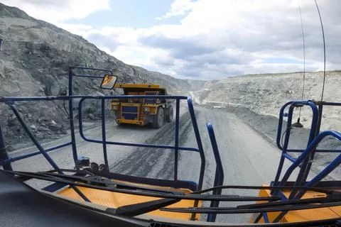 Two mining trucks are driving along the road in the quarry towards each oth.. Stock Photos