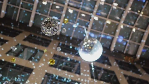 Two mirrored disco balls are suspended from the ceiling inside a high-rise Stock Footage 169003420