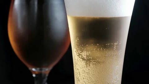 Two misted glass with cold light and dark beer. bubbles. stock footage. Stock Footage 133730465