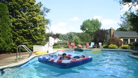 Two mixed boys have a fun in the swimming pool Video stock 136491943