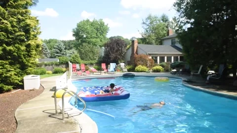 Two mixed boys have a fun in the swimming pool Video stock 136491966