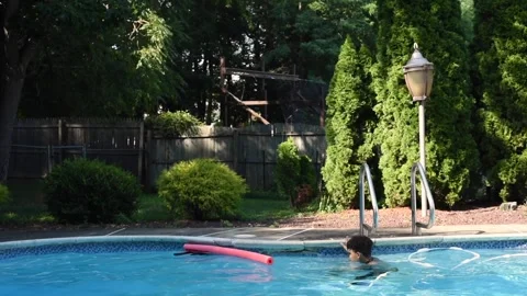 Two mixed boys have a fun in the swimming pool Video stock 136492308
