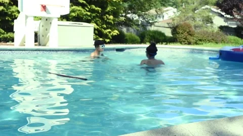 Two mixed boys have a fun in the swimming pool Video stock 136492505