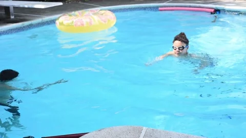Two mixed boys have a fun in the swimming pool Video stock 136492506