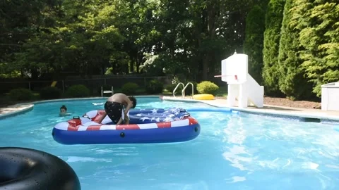 Two mixed boys have a fun in the swimming pool Video stock 136492703