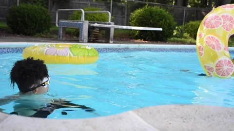 Two mixed boys have a fun in the swimming pool Stock Footage 136492971