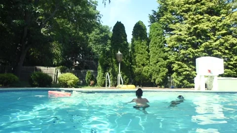 Two mixed boys have a fun in the swimming pool Stock Footage 136492984