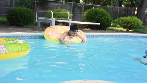 Two mixed boys have a fun in the swimming pool Stock Footage 136493069