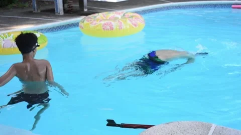 Two mixed boys have a fun in the swimming pool Stock Footage 136493239
