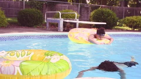 Two mixed boys have a fun in the swimming pool Stock Footage 136493341