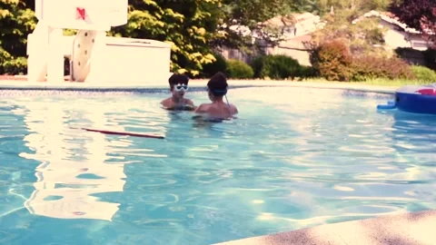 Two mixed boys have a fun in the swimming pool Stock Footage 136493361