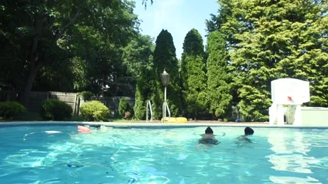 Two mixed boys have a fun in the swimming pool Stock Footage 136493515