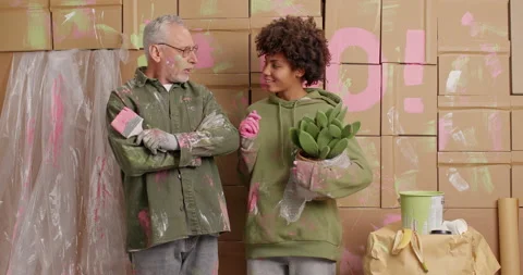 Two mixed race painters have pleasant conversation discuss together how to Stock Footage 144922495